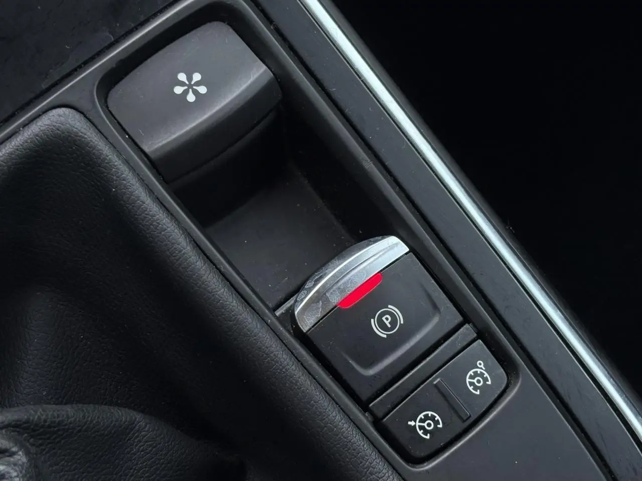 Gros plan sur la console centrale noire du Renault Grand Scénic IV avec frein de parking électrique et commandes de régulateur.