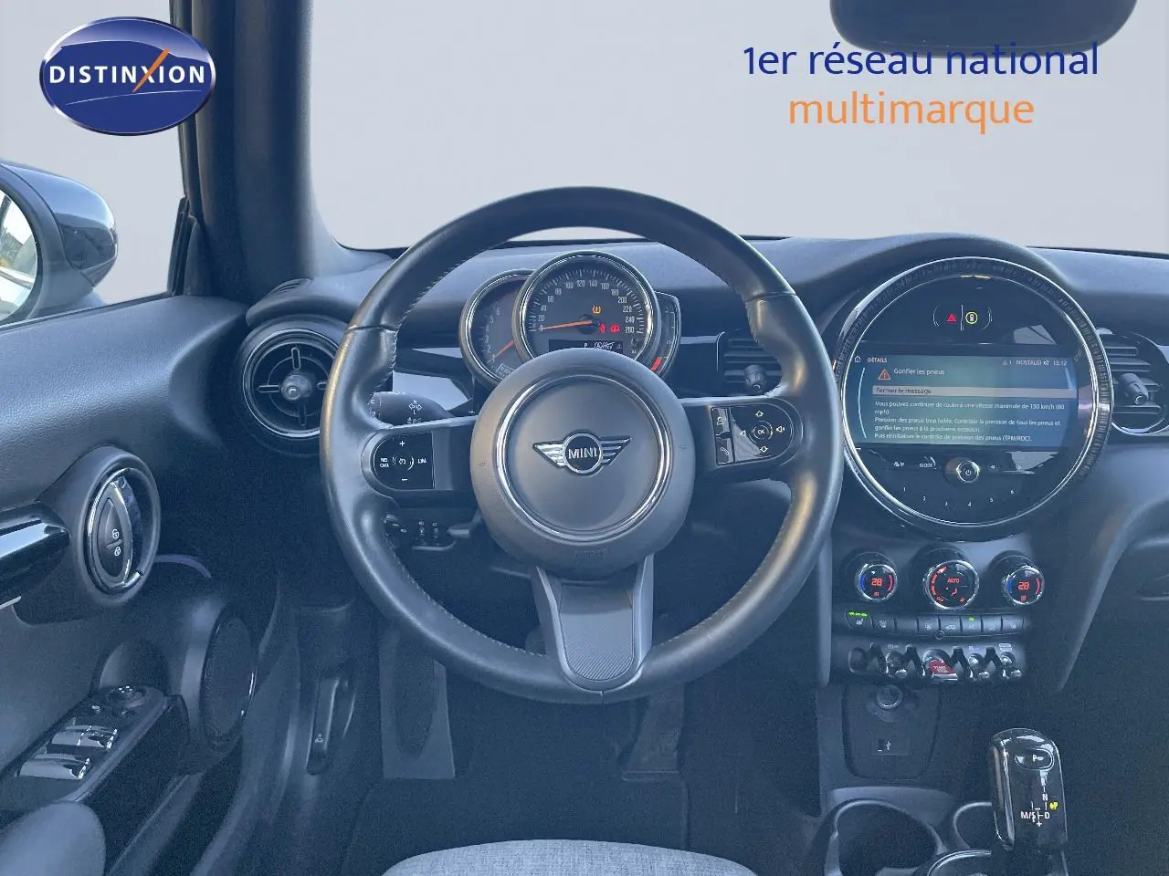 Vue intérieure centrée sur le volant et tableau de bord de la MINI Cabriolet F57 noir avec écran digital et commandes modernes.