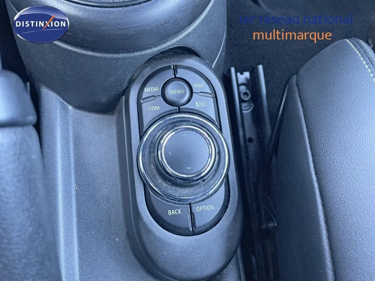 Gros plan sur la molette de commande centrale noire du MINI Cabriolet F57 2023, entourée de boutons fonctionnels.