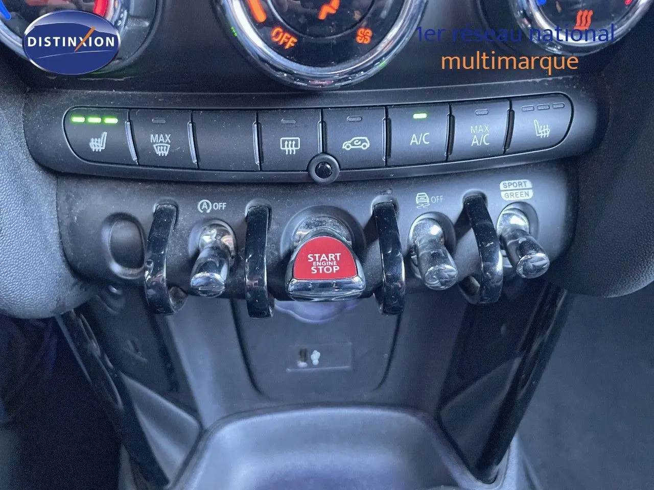 Détail du tableau de bord de la MINI Cabriolet F57 2023, mettant en valeur les commandes de climatisation et le bouton start/stop rouge.