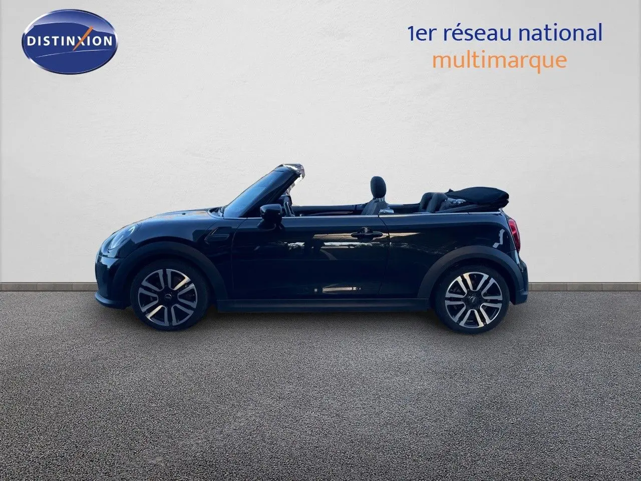 Profil côté gauche d'une MINI Cabriolet F57 noire Midnight Metal avec capote ouverte, vue extérieure sur fond clair.