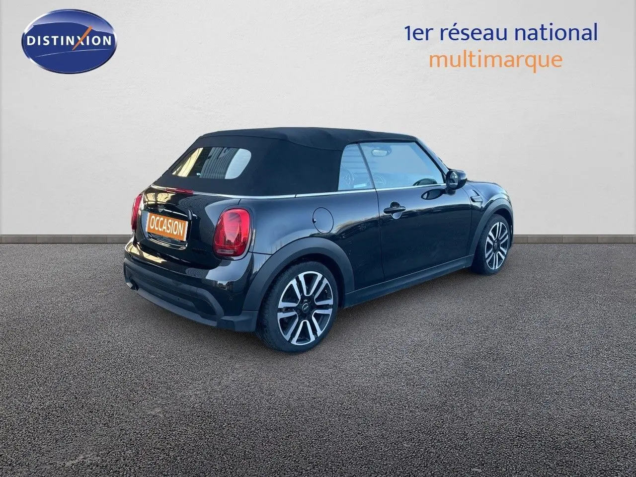 Vue 3/4 arrière droite d'une MINI Cabriolet F57 noire Midnight Metal avec capote fermée sur fond neutre.