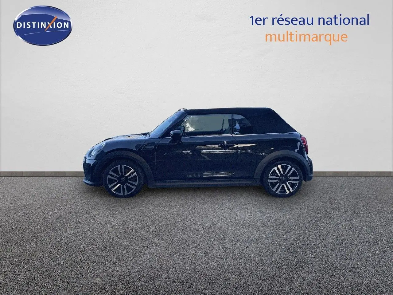 Profil côté gauche d'une MINI Cabriolet F57 noire Midnight Metal avec capote fermée sur fond neutre.