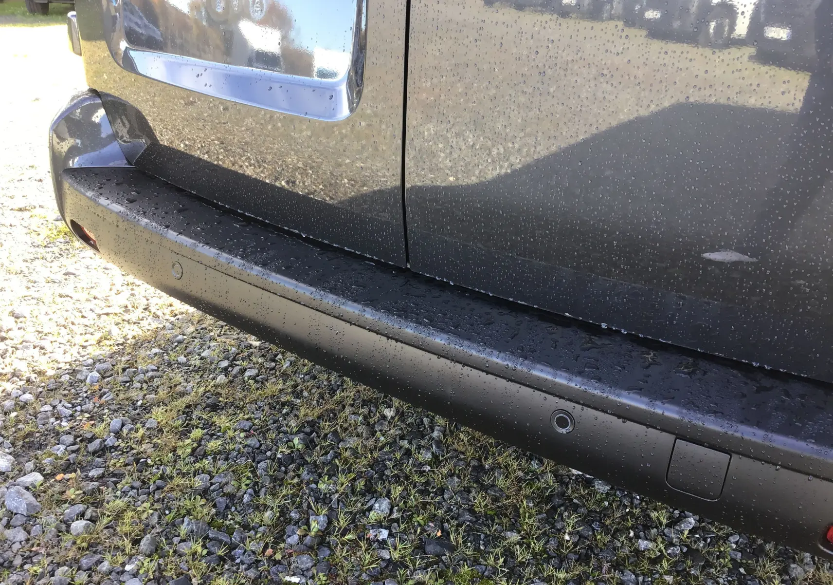 Gros plan sur la partie arrière droite gris titane d'un Citroën Jumpy Cabine Approfondie avec capteurs de recul visibles.