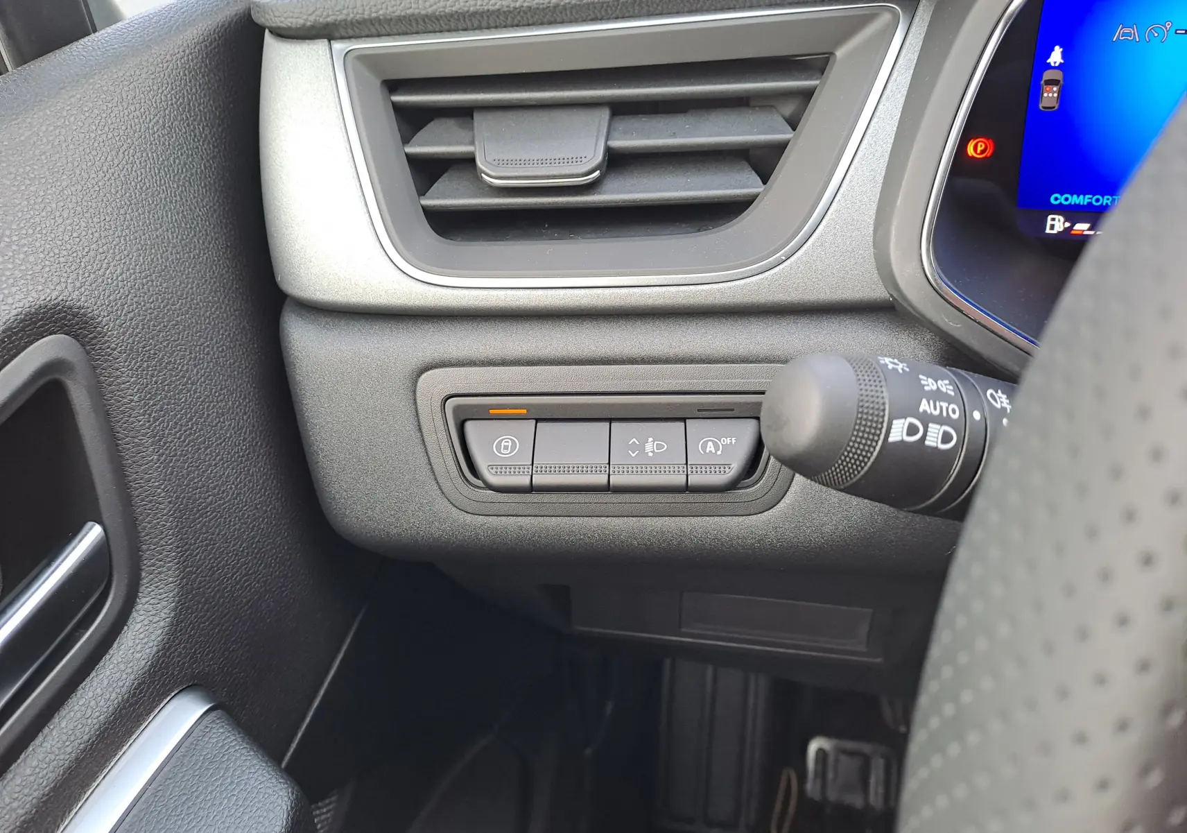Vue intérieure côté gauche du tableau de bord gris noir du Renault Symbioz, avec commandes d’éclairage et ventilation.