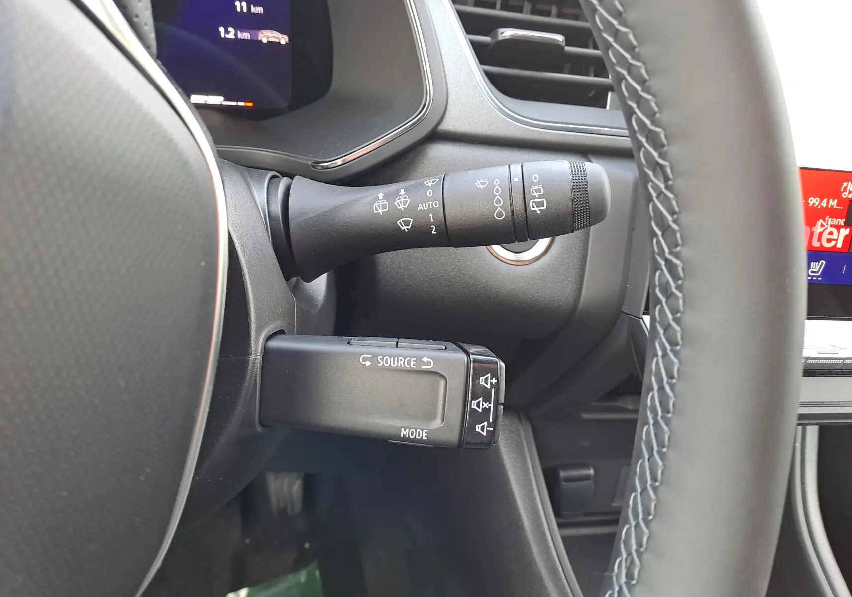 Gros plan sur la commande multifonction et le commodo d’essuie-glace à gauche du volant du Renault Symbioz gris Cassiopée.