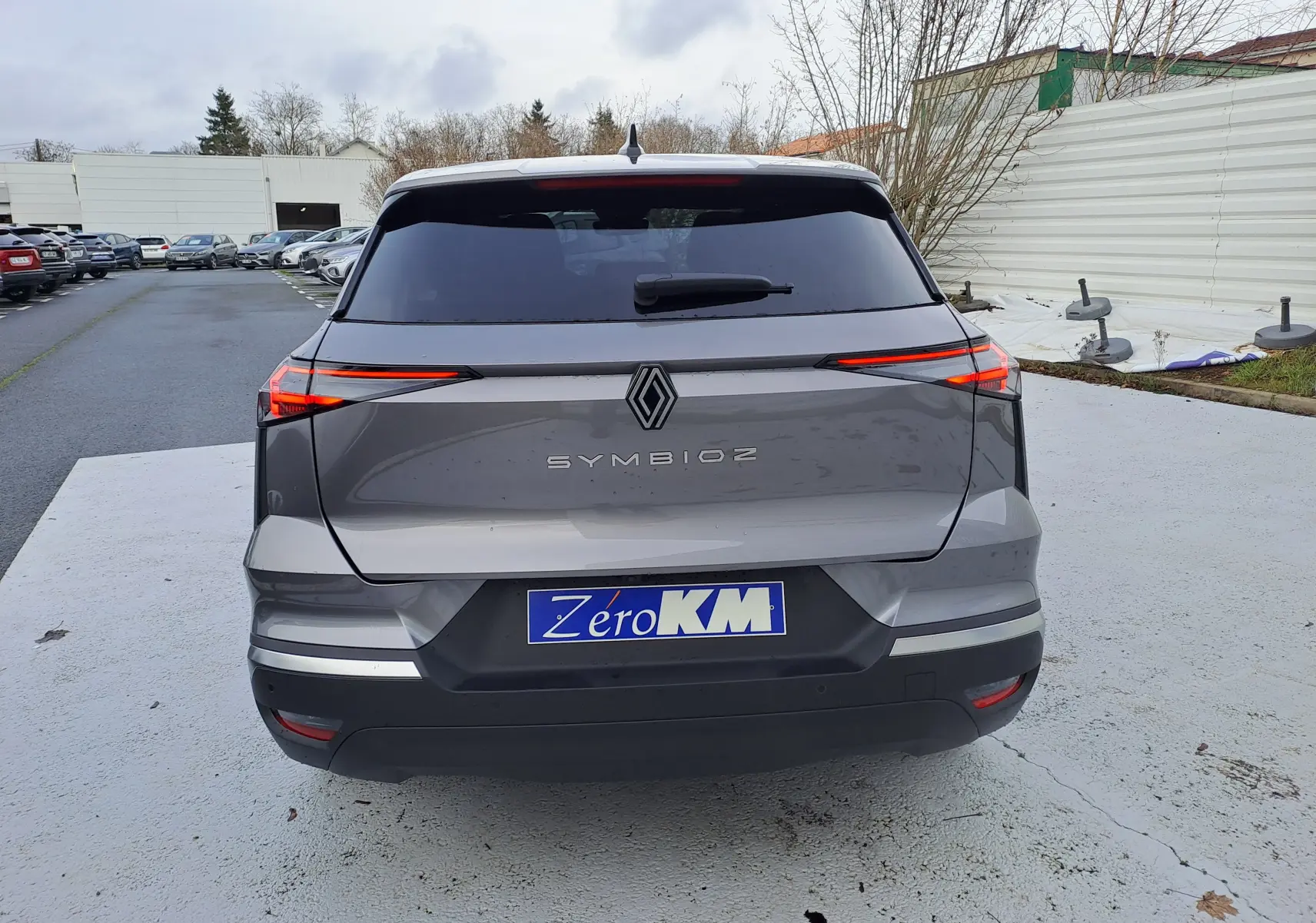 Vue arrière d’un Renault Symbioz gris Cassiopée avec feux LED fins et plaque d’immatriculation Zero KM.