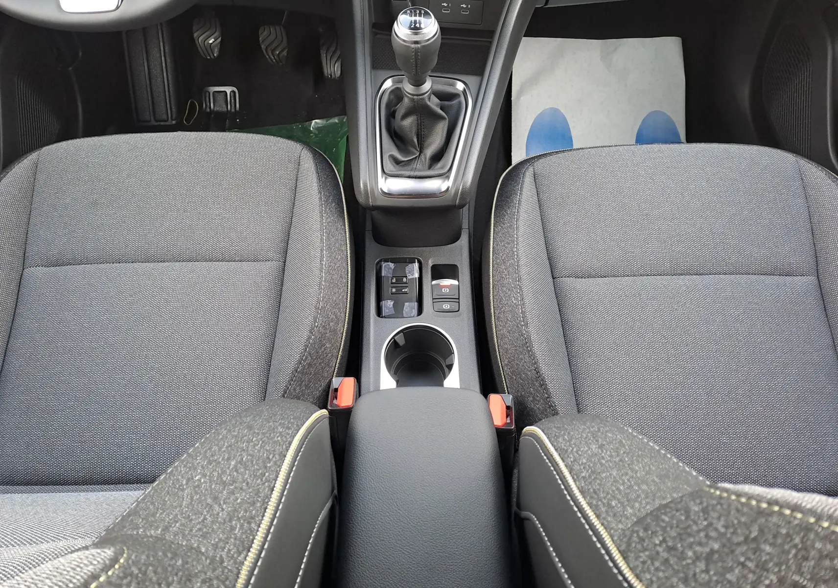 Vue plongeante sur l’intérieur noir du Renault Symbioz 2025, mettant en valeur la console centrale avec levier de vitesse manuel.