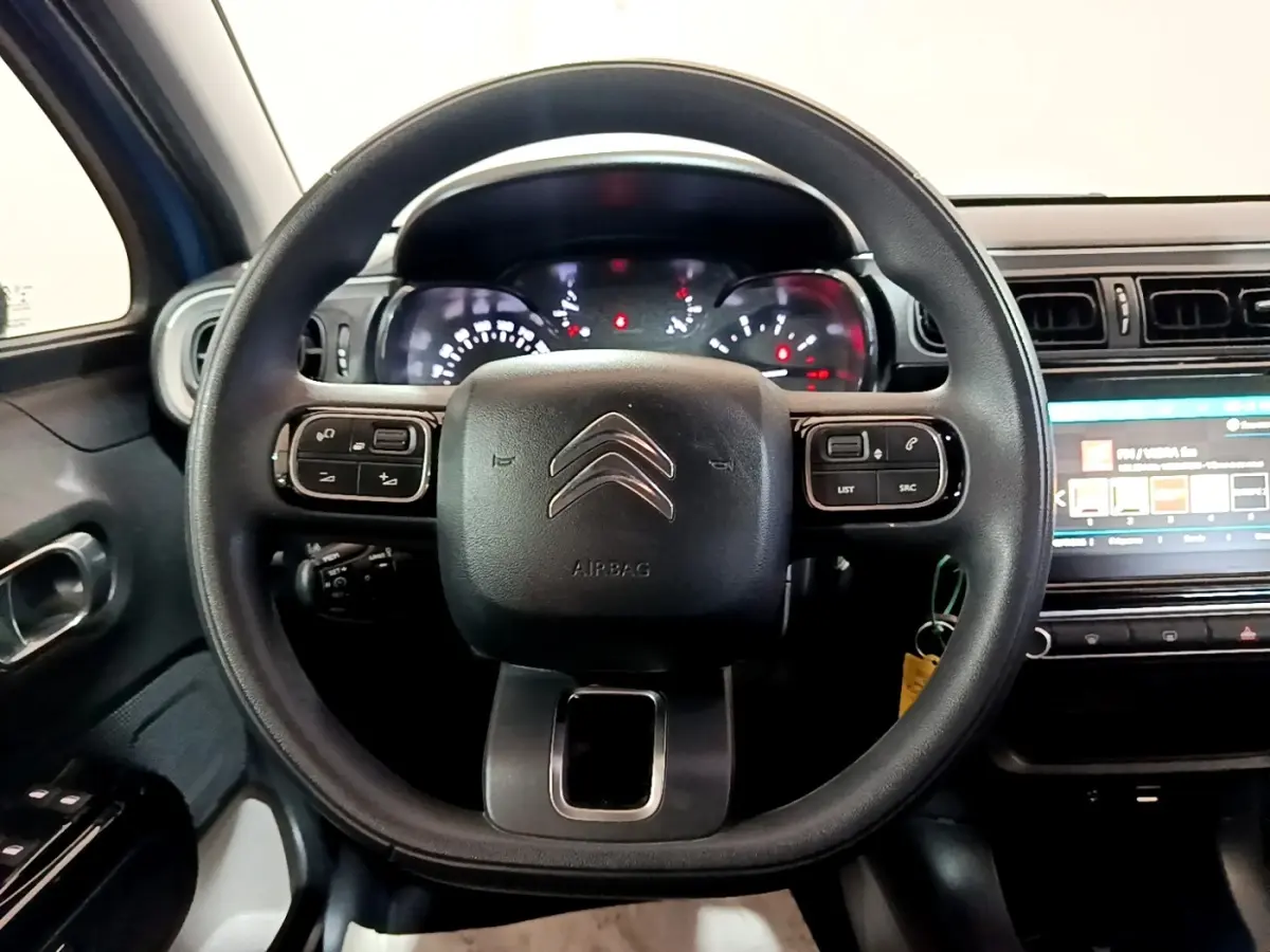 Vue rapprochée du volant multifonctions noir de la Citroën C3 2017 avec tableau de bord et écran tactile visible.