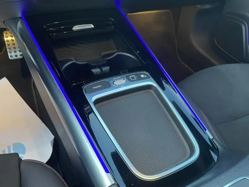 Vue rapprochée de la console centrale noire avec éclairage bleu intérieur du Mercedes GLA 250 e AMG LINE 2025.