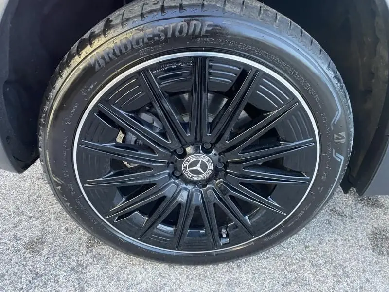 Gros plan sur la jante noire brillante d’un Mercedes GLA 250 e AMG Line 2025 avec pneu Bridgestone, couleur gris foncé métal.