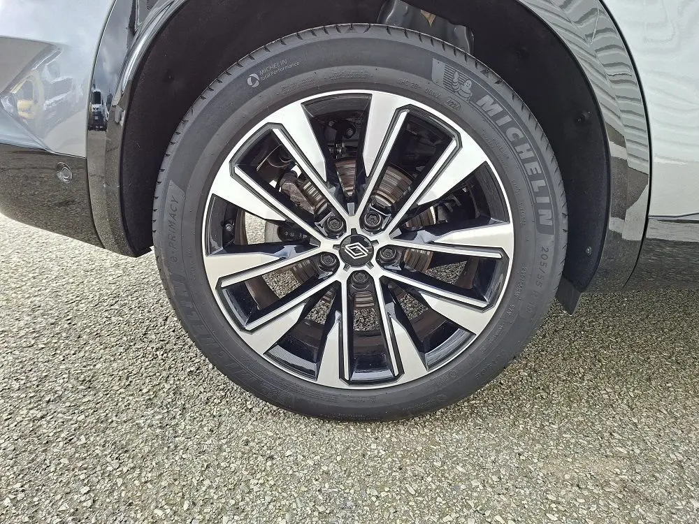 Gros plan sur la roue avant droite du Renault Austral gris schiste, avec jante alliage bicolore et pneu Michelin.