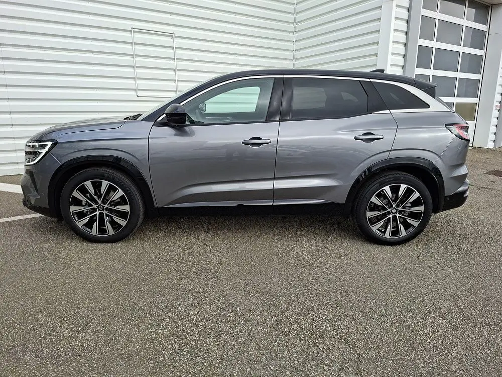 Renault Austral E-Tech gris schiste vu de profil côté gauche, avec jantes alliage et lignes épurées.