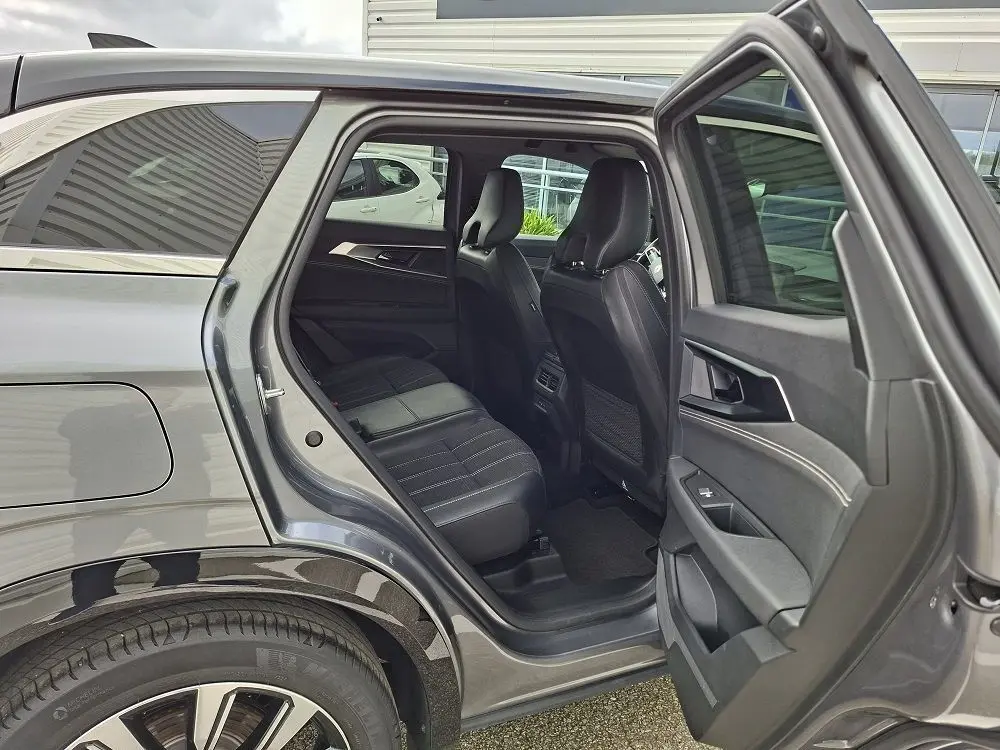 Vue côté gauche arrière du Renault Austral gris schiste, porte ouverte dévoilant l’habitacle et les sièges noirs.