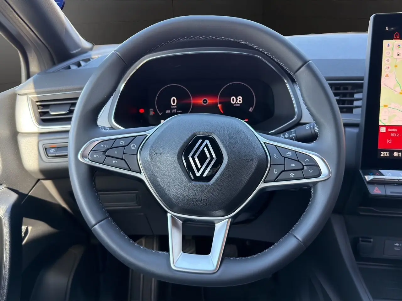Vue rapprochée du volant cuir noir et du tableau de bord numérique du Renault Captur TCe 90 Techno 2024.