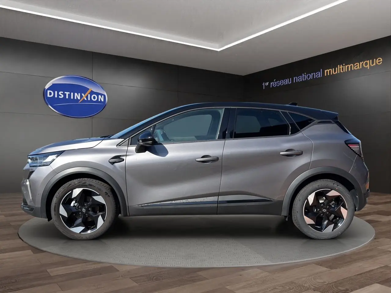 Profil droit du Renault Captur TCE 90 Techno 2024 gris Cassiopée avec toit noir et jantes bi-ton distinctives.