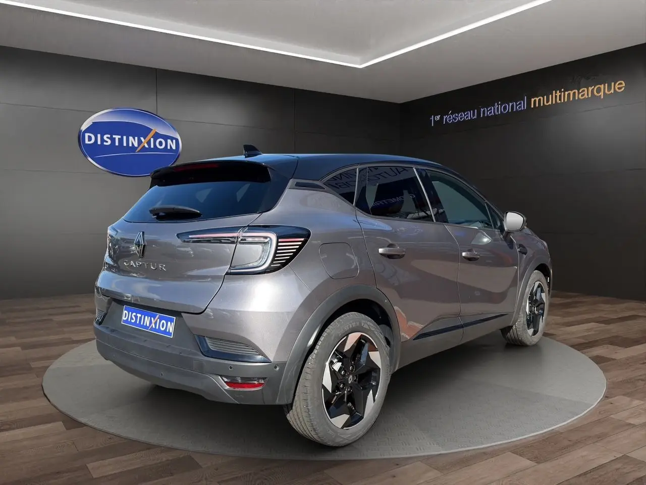 Vue 3/4 arrière droite d’un Renault Captur 2024 gris Cassiopée avec toit noir et jantes noires bicolores.