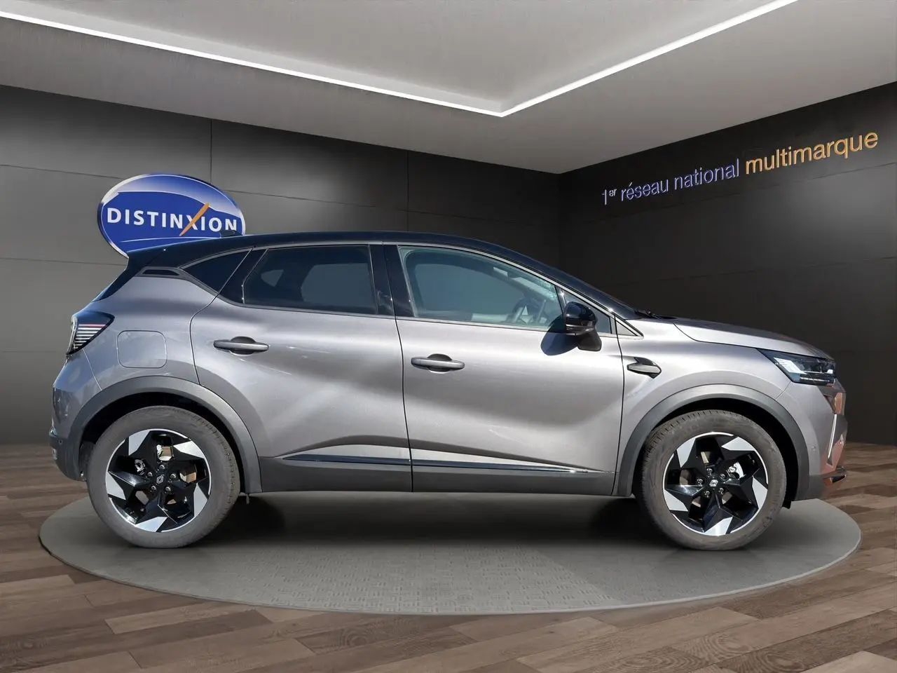 Vue de profil côté gauche d'un Renault Captur TCE 90 Techno gris Cassiopée avec toit noir et jantes bicolores.