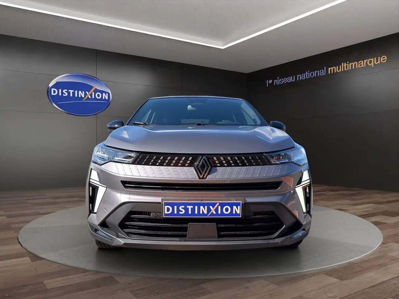 Vue frontale d'une Renault Captur 2024 gris Cassiopée avec toit noir, calandre moderne et logo Renault central.