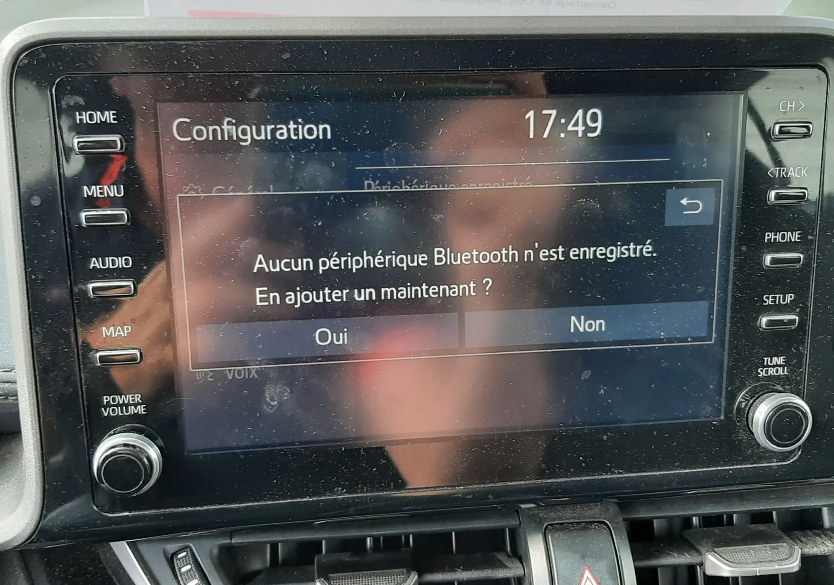 Écran tactile central du Toyota C-HR 1.8 Hybrid 2021 affichant un message Bluetooth, avec commandes autour et tableau de bord gris.