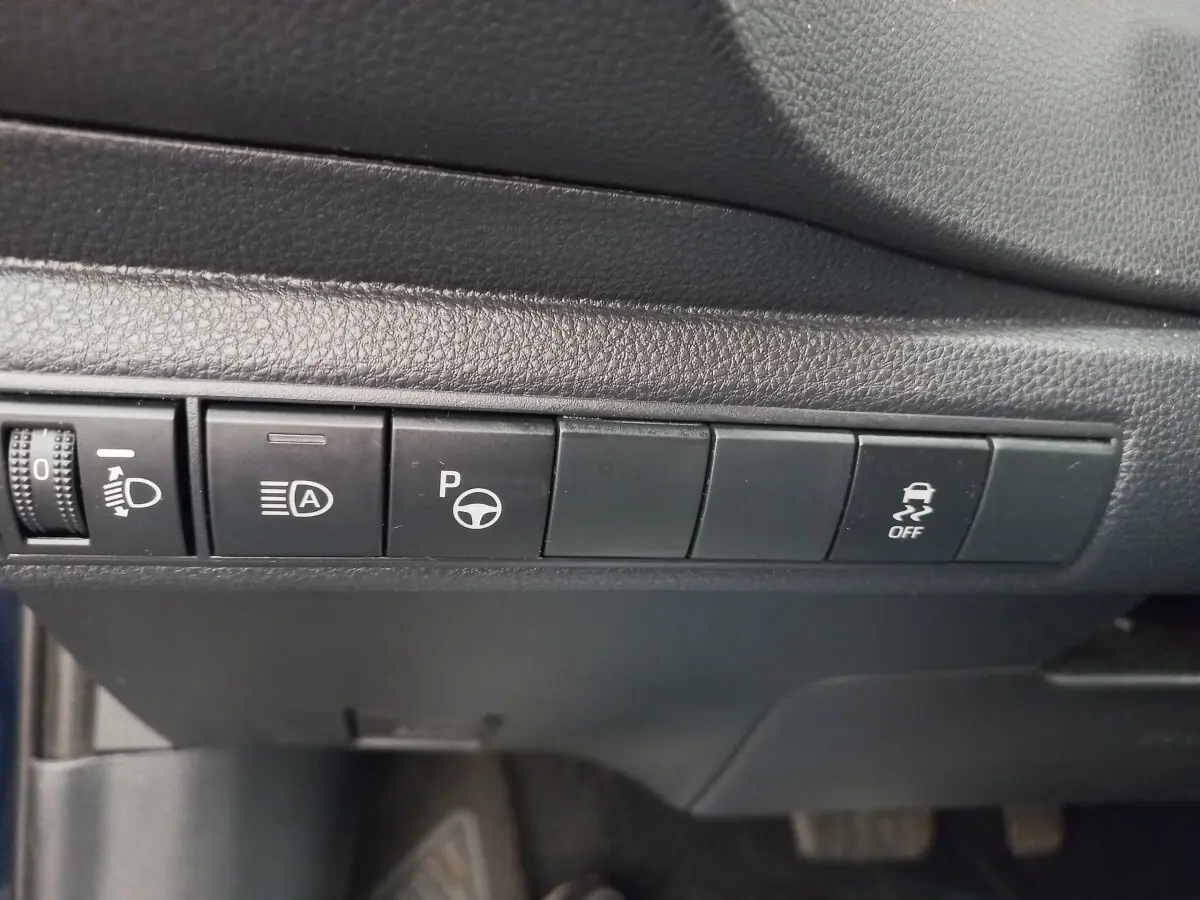 Gros plan sur les boutons de commande noirs du tableau de bord intérieur de la Toyota Corolla hybride 2022.