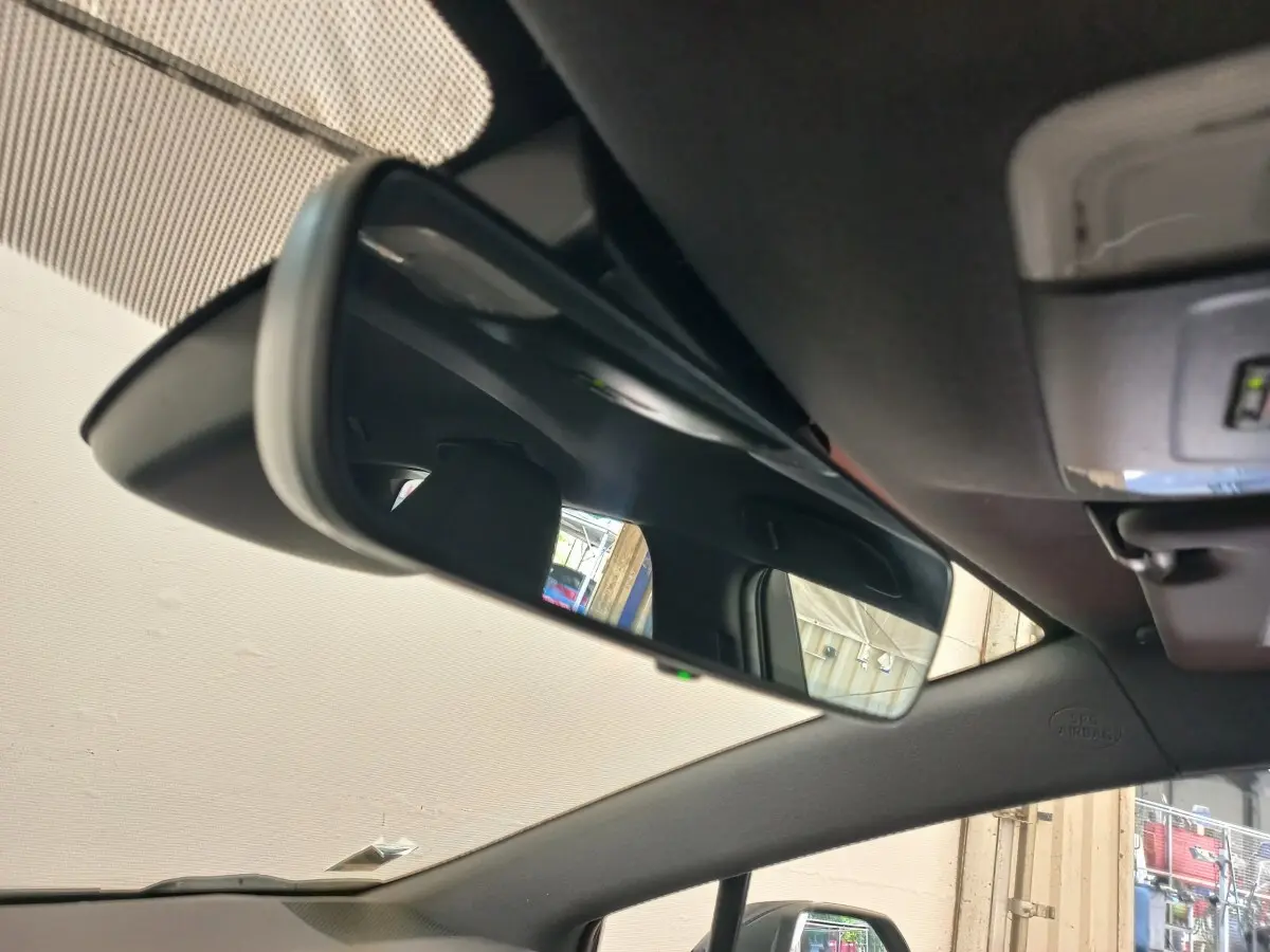 Rétroviseur intérieur de la Toyota Corolla hybride 2022, vue rapprochée de l'habitacle avec reflet du siège et fenêtre.