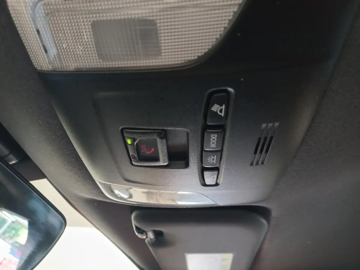 Vue intérieure du plafonnier avec commandes d'éclairage et bouton SOS dans une Toyota Corolla hybride bleue 2022.