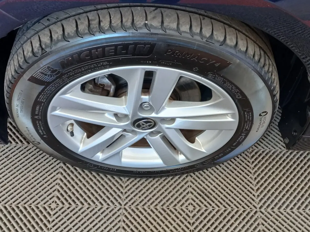 Gros plan sur la roue avant droite de la Toyota Corolla hybride bleue avec jante alliage et pneu Michelin Primacy 4.