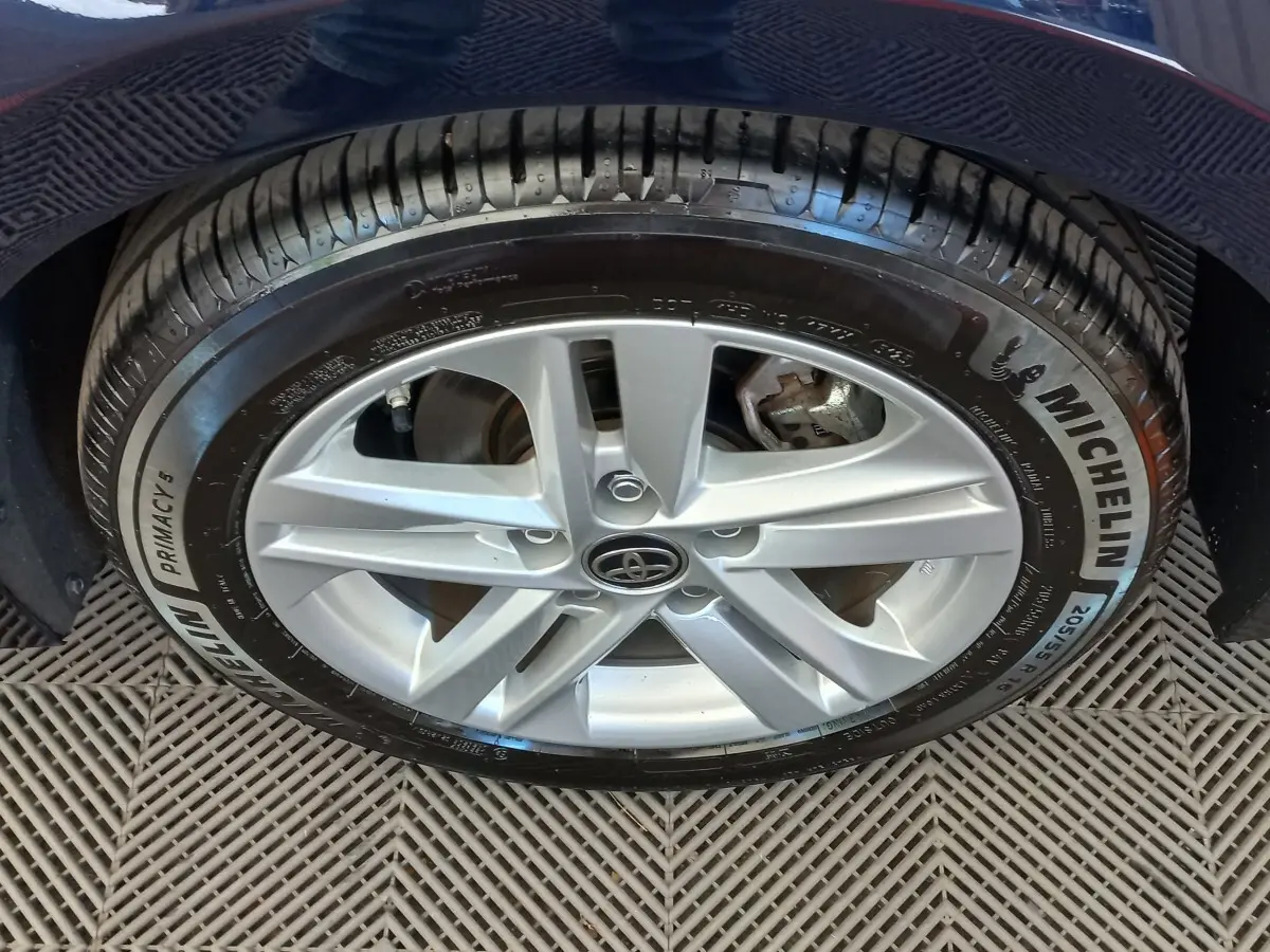 Gros plan sur la roue avant droite de la Toyota Corolla hybride bleue, avec jante argentée et pneu Michelin.