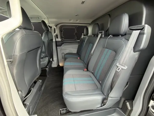 Vue intérieure du côté droit du Ford Transit Fourgon 2026, montrant la banquette arrière en cuir noir avec inserts gris et bleus.