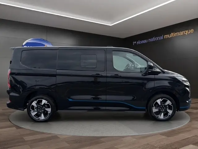 Ford Transit Fourgon noir vue de profil côté droit, avec jantes modernes et lignes épurées.
