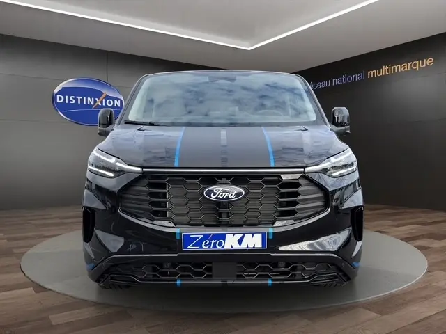 Vue de face du Ford Transit Fourgon noir avec bandes bleues sur le capot et calandre hexagonale distinctive.