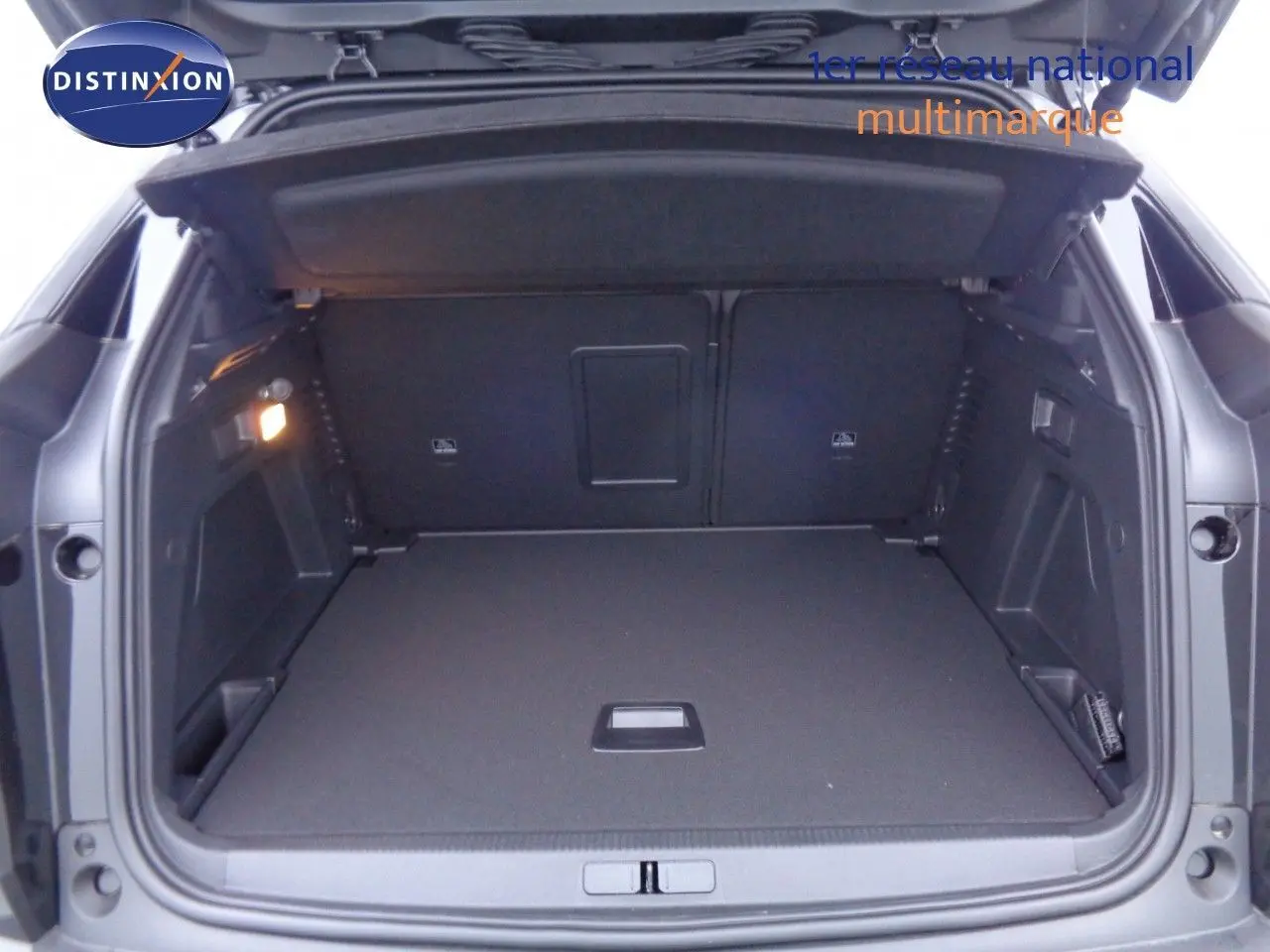 Coffre ouvert du Peugeot 3008 noir perla metal, vue arrière montrant un espace de chargement spacieux et bien éclairé.