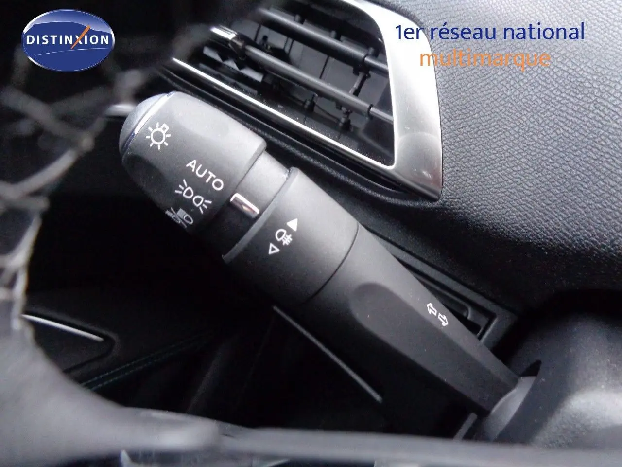 Gros plan sur la commande des feux et clignotants dans l'habitacle noir du Peugeot 3008 2023.