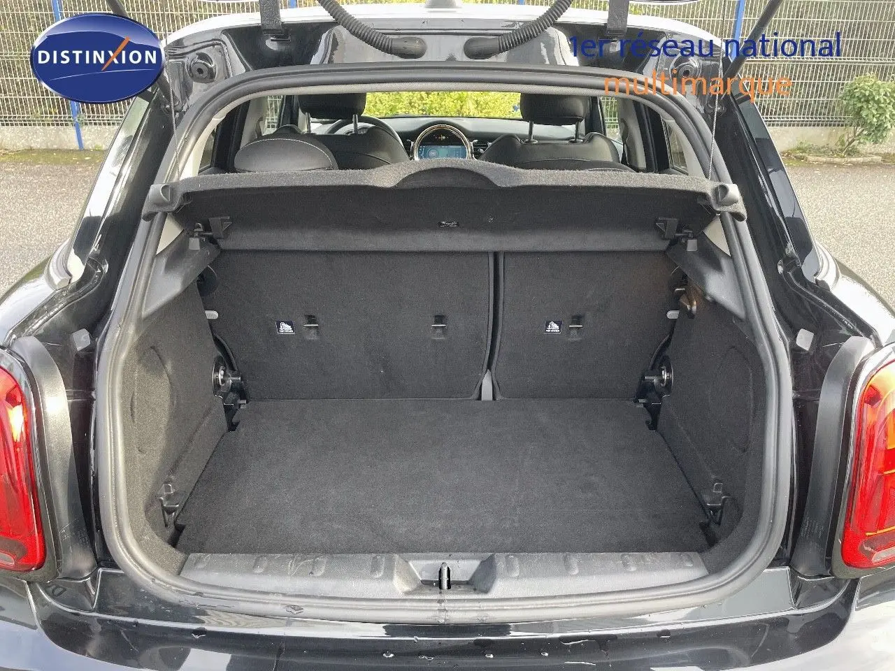 Coffre ouvert vu de l'arrière d'une MINI noire Midnight Metal 2023, montrant l'espace de chargement vide.