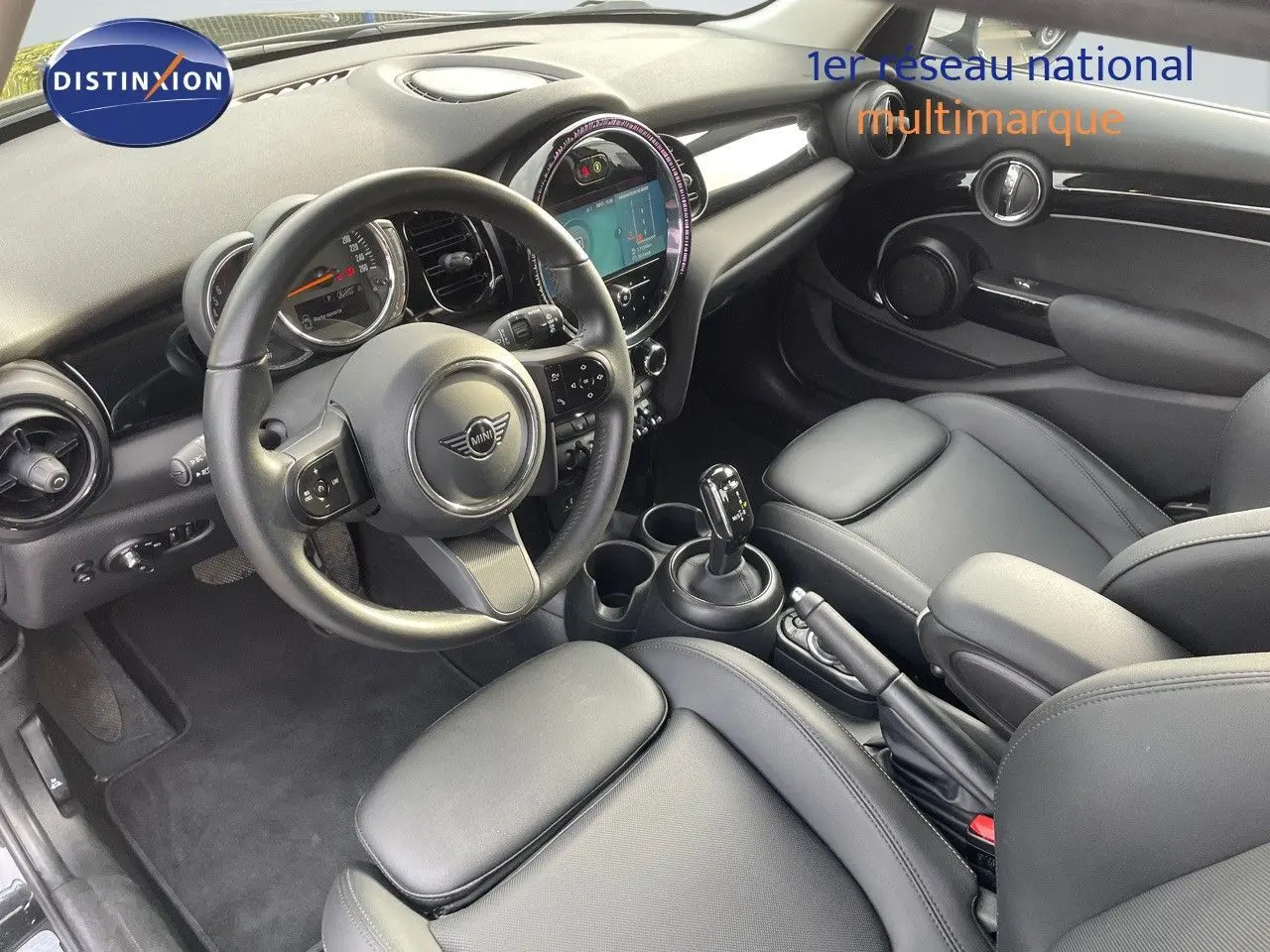 Intérieur noir cuir de MINI 1.5 136CH, vue depuis le côté conducteur sur volant, tableau de bord et console centrale.