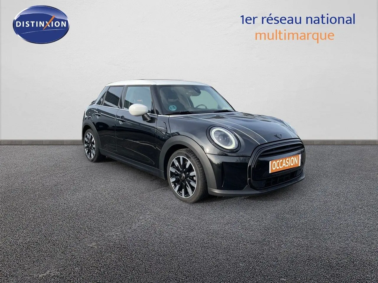 Vue 3/4 avant droite d'une MINI 1.5 136CH noire Midnight Metal avec toit et rétroviseurs blancs, en extérieur.