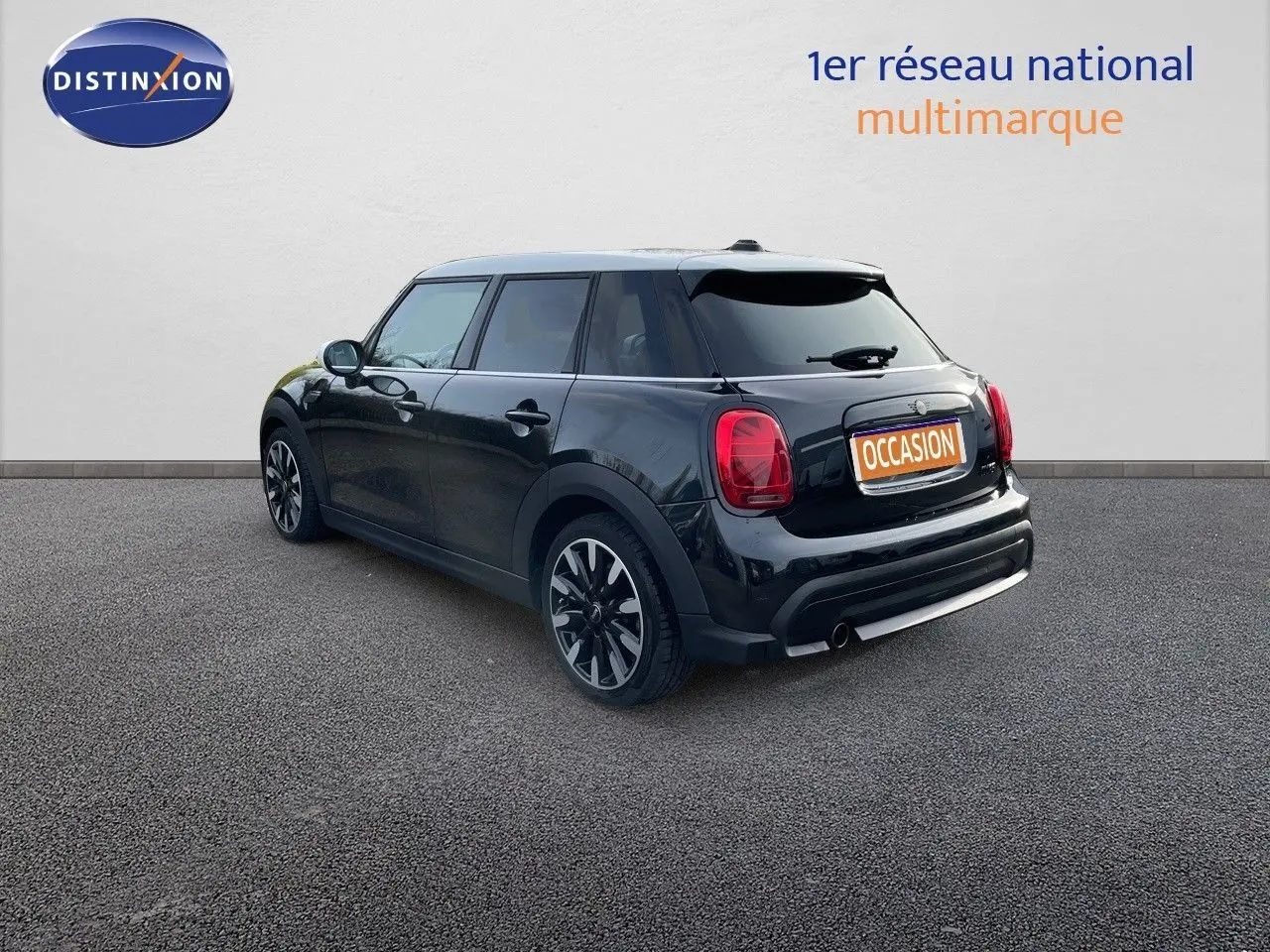 Vue 3/4 arrière droite d'une MINI 1.5 136CH noire Midnight Metal avec jantes biton et feux arrière LED.
