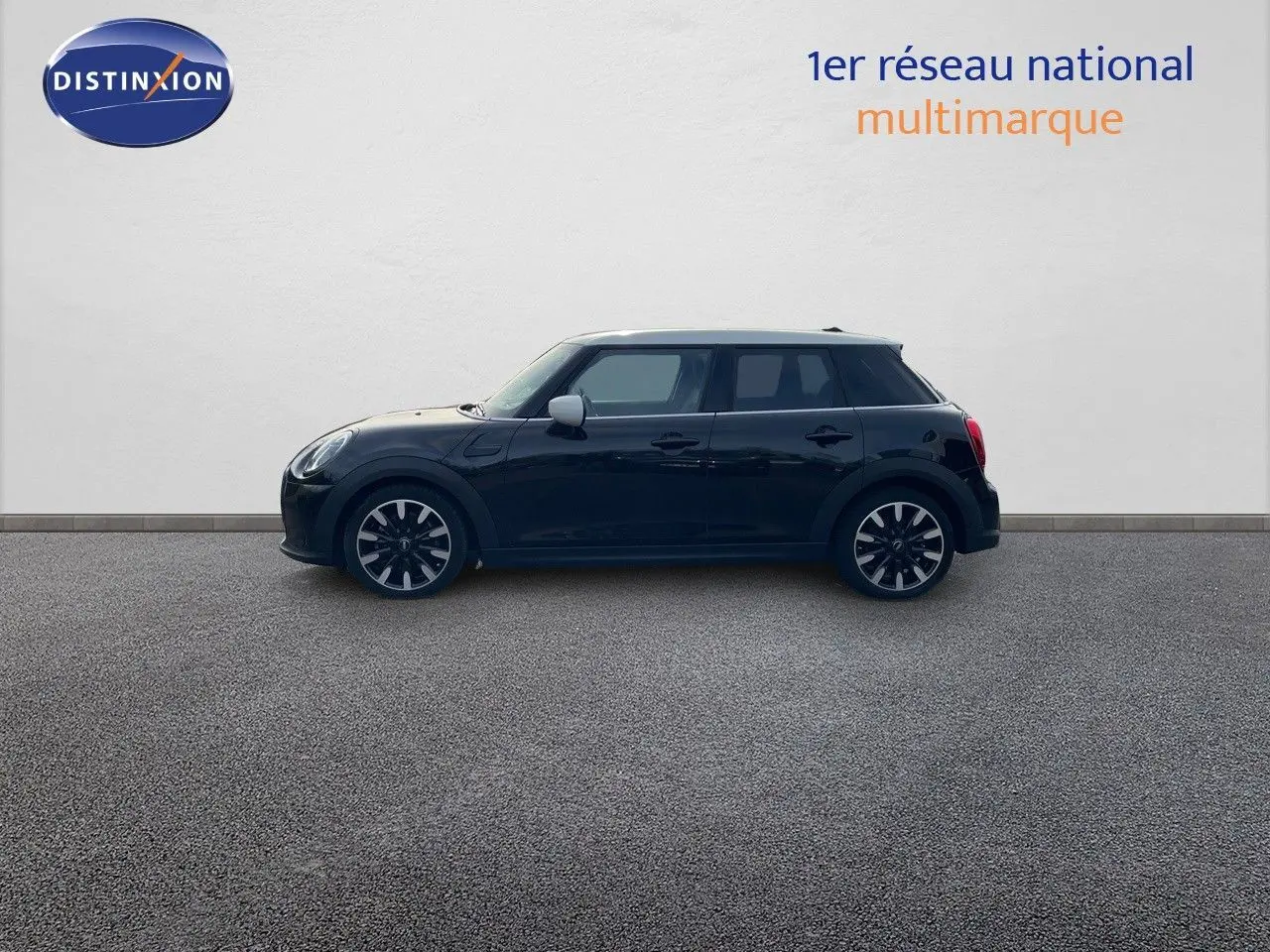 Profil droit d'une MINI 1.5 136CH STEPTRONIC noire Midnight Metal avec toit blanc et jantes bi-ton 17 pouces.