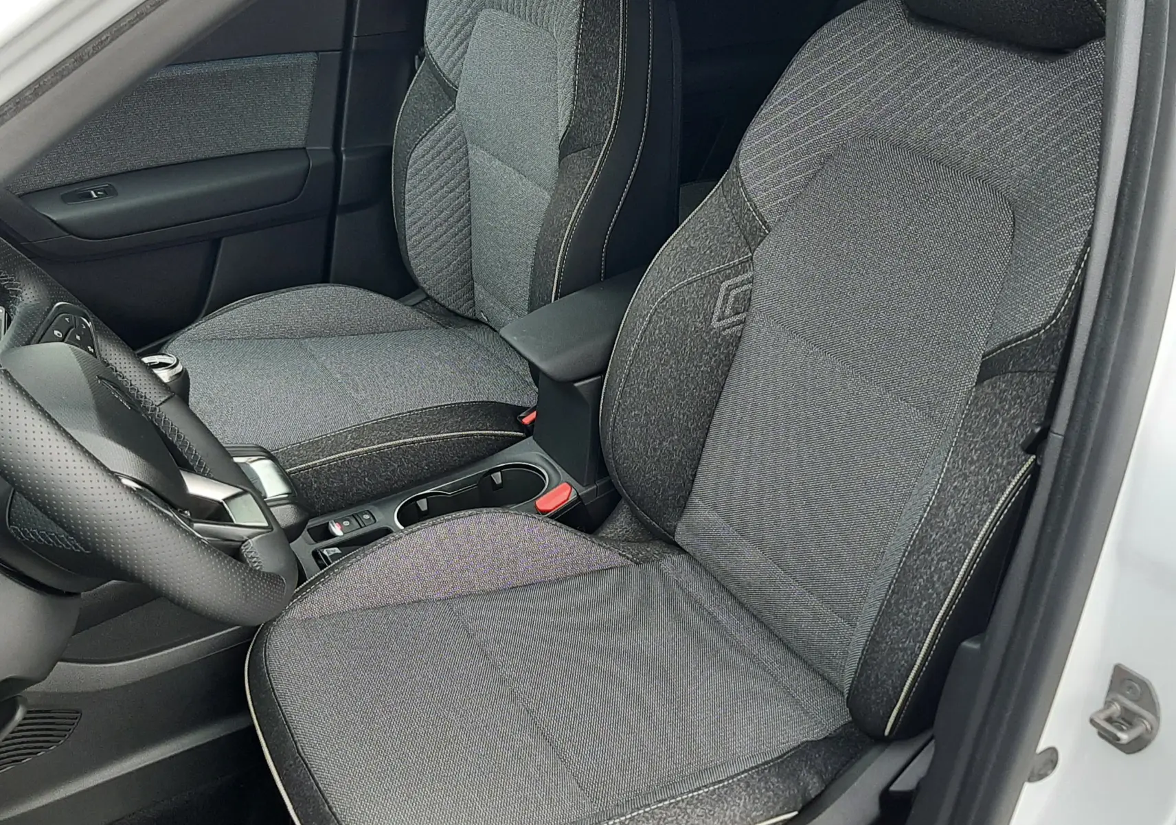 Vue intérieure côté gauche du Renault Symbioz blanc nacré 2025, sièges tissu gris avec surpiqûres claires.