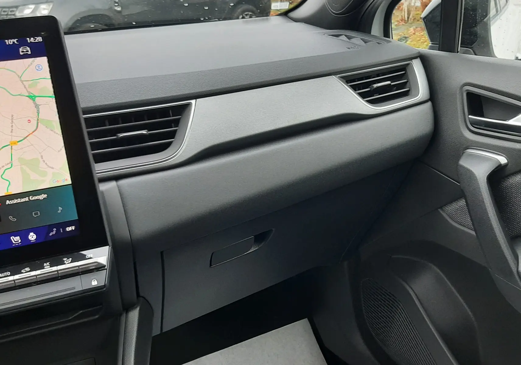 Vue intérieure côté passager du tableau de bord noir et de la boîte à gants du Renault Symbioz blanc nacré 2025.