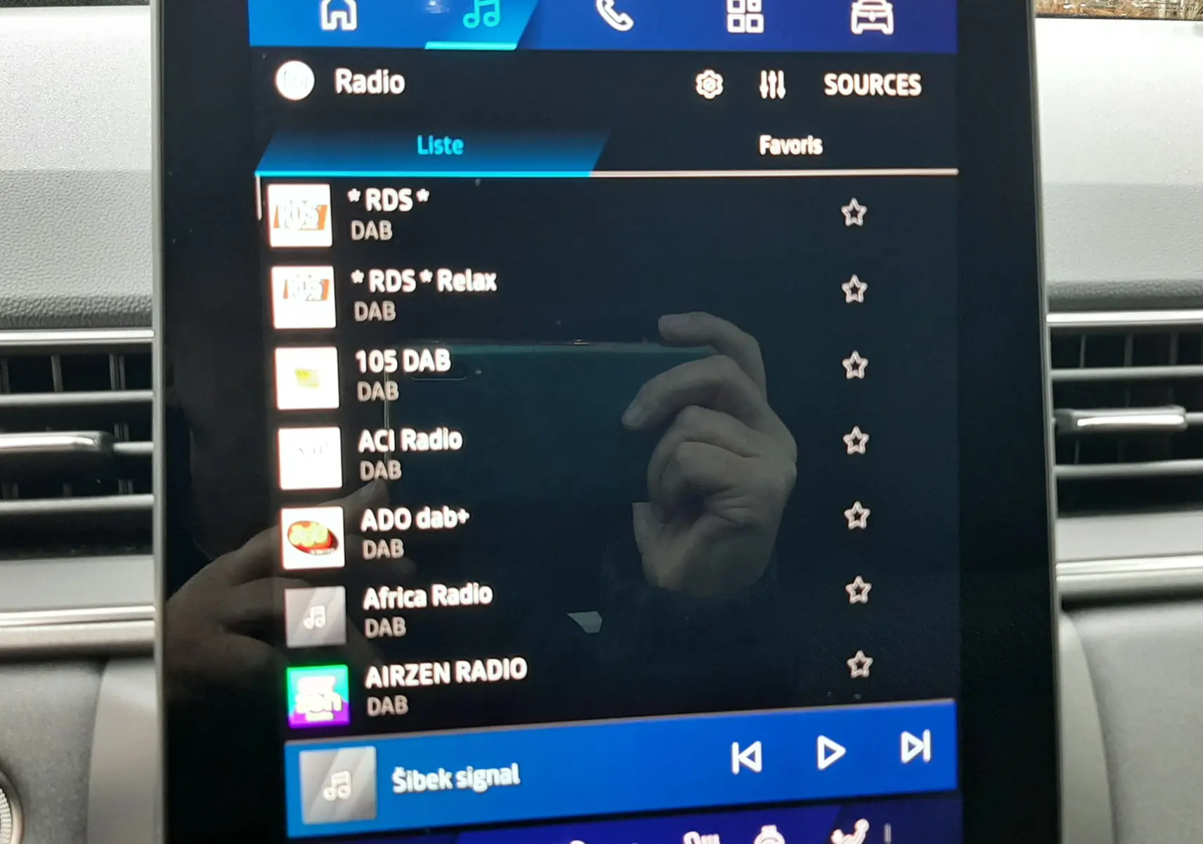 Écran tactile central du tableau de bord du Renault Symbioz blanc nacré, affichant les stations radio DAB.