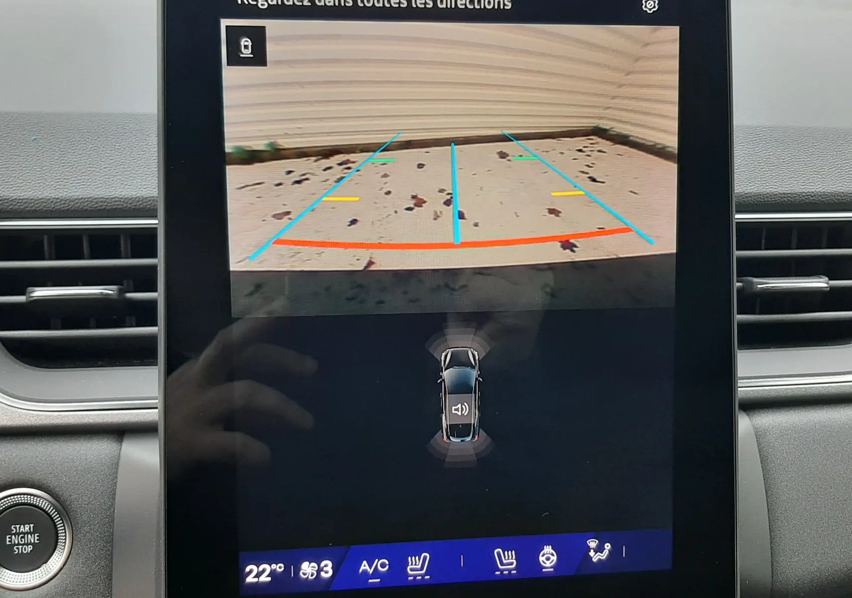 Écran central de Renault Symbioz blanc nacré montrant la caméra de recul avec lignes de guidage colorées.