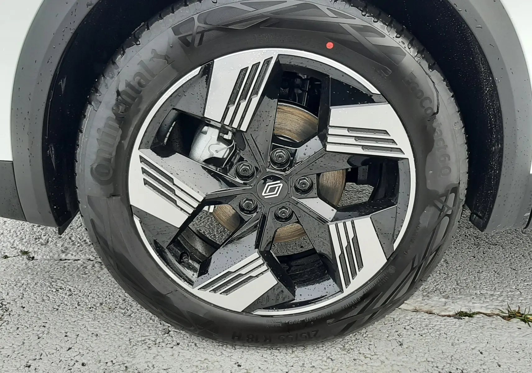 Gros plan sur la roue avant droite du Renault Symbioz blanc nacré avec jante alliage bicolore au design moderne.