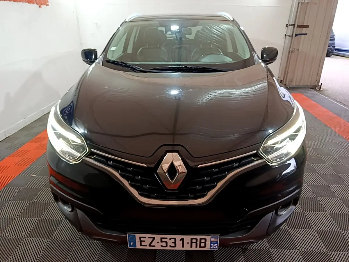 Vue frontale d'un Renault Kadjar Intens noir avec phares LED allumés dans un garage intérieur.