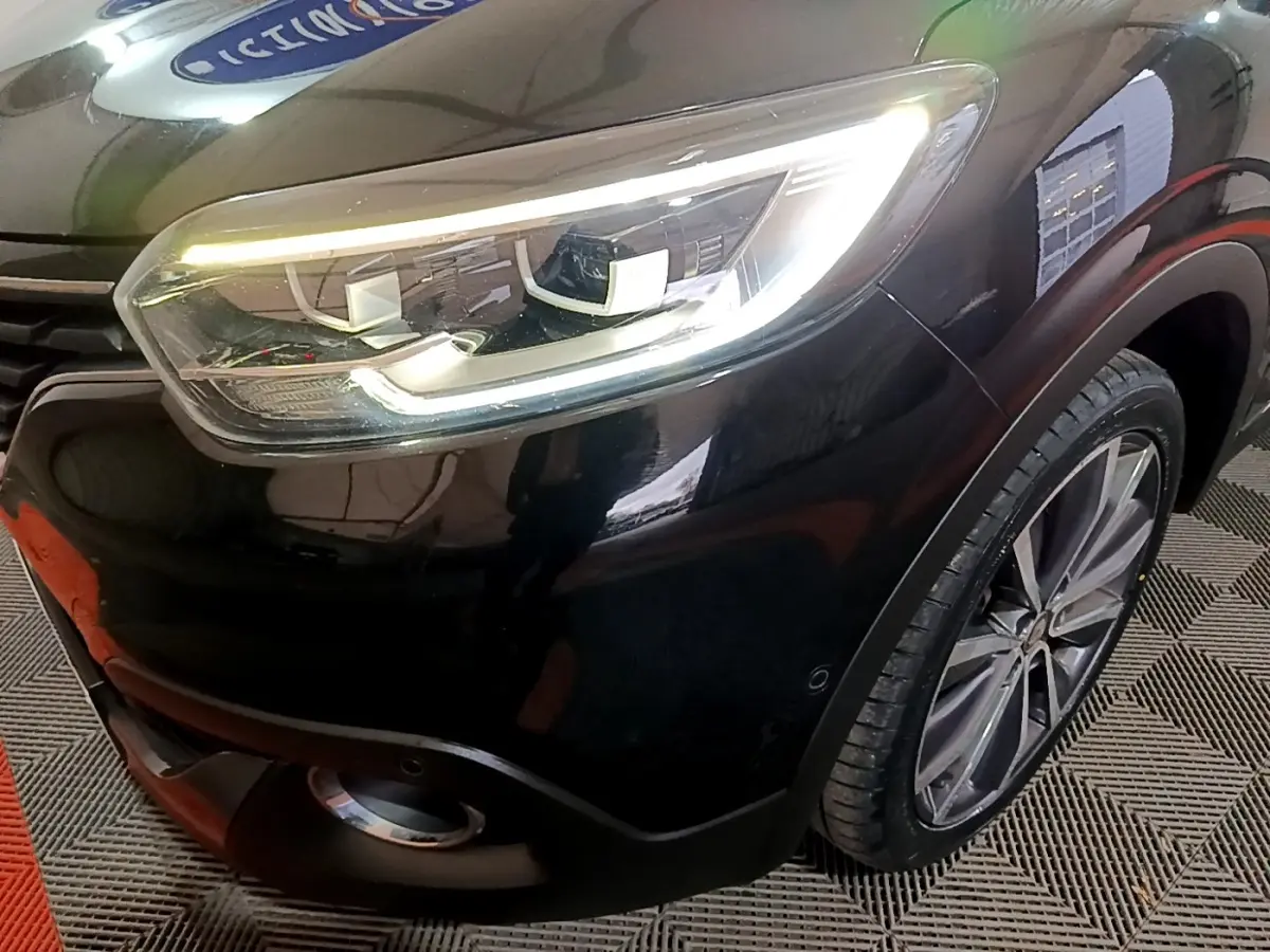 Gros plan sur l'avant droit noir du Renault Kadjar Intens avec phare LED allumé et jante alliage visible.