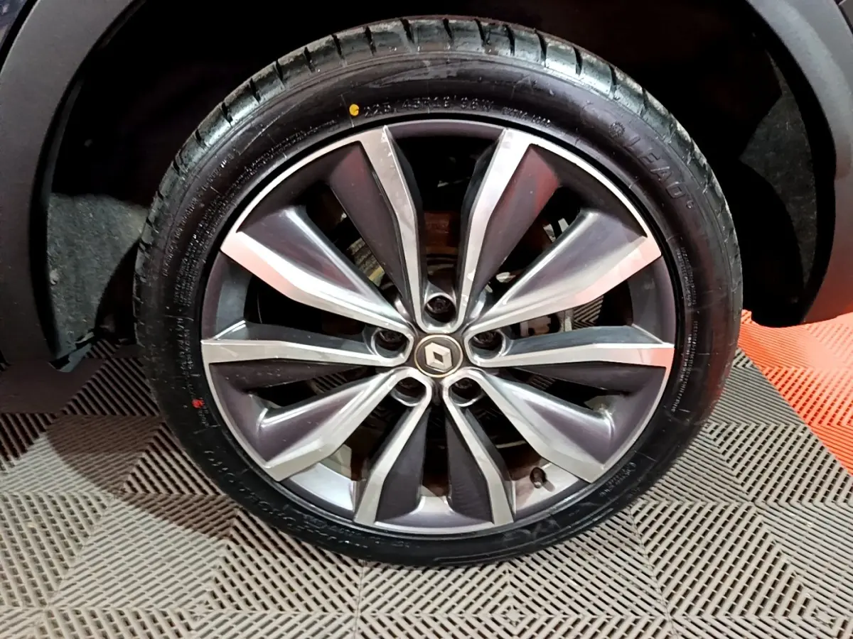 Gros plan sur la jante alliage du Renault Kadjar noir, soulignant le design moderne à branches bicolores.