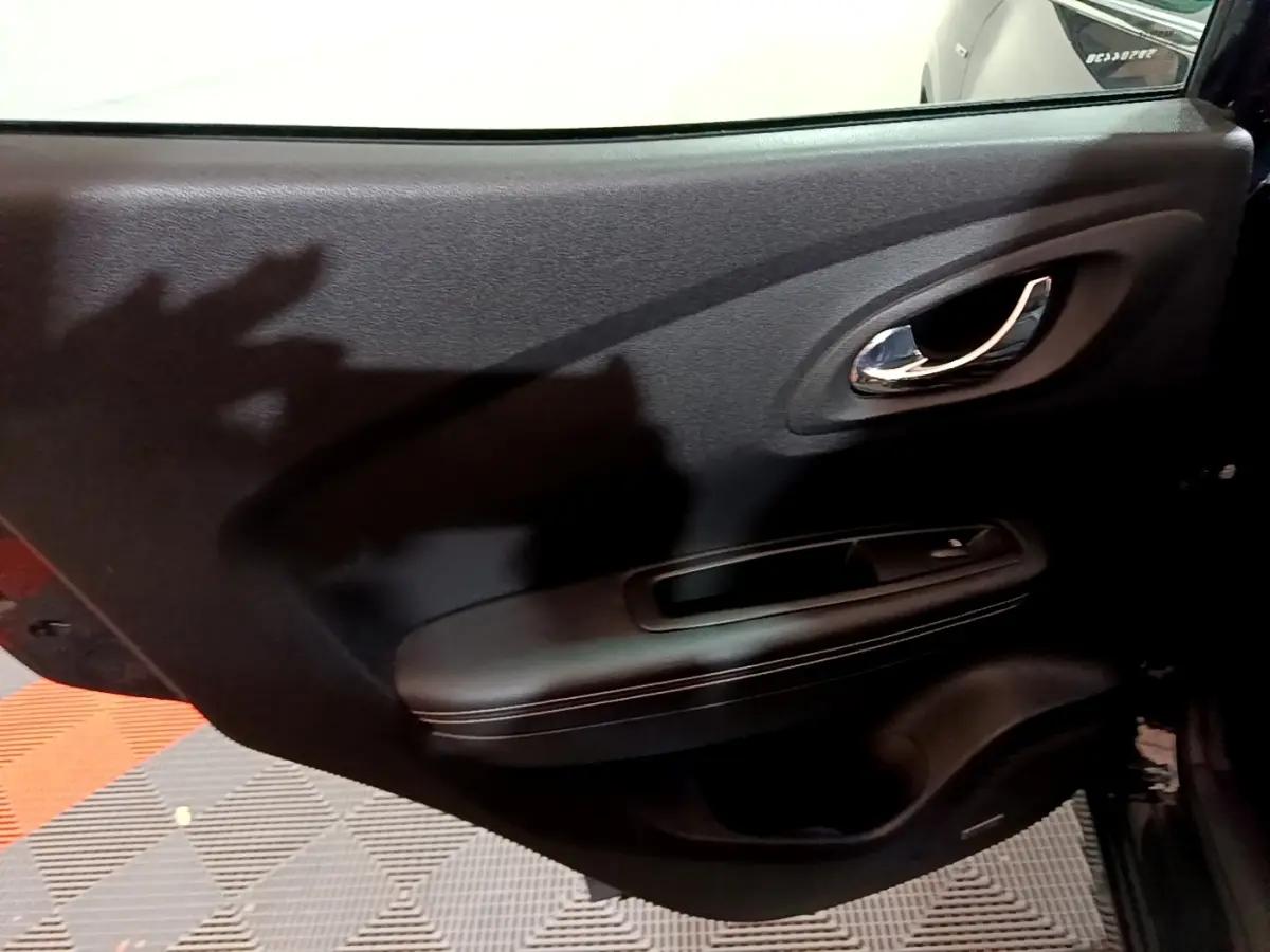 Gros plan sur la porte intérieure arrière droite noire du Renault Kadjar Intens 2018 avec poignée chromée et accoudoir.