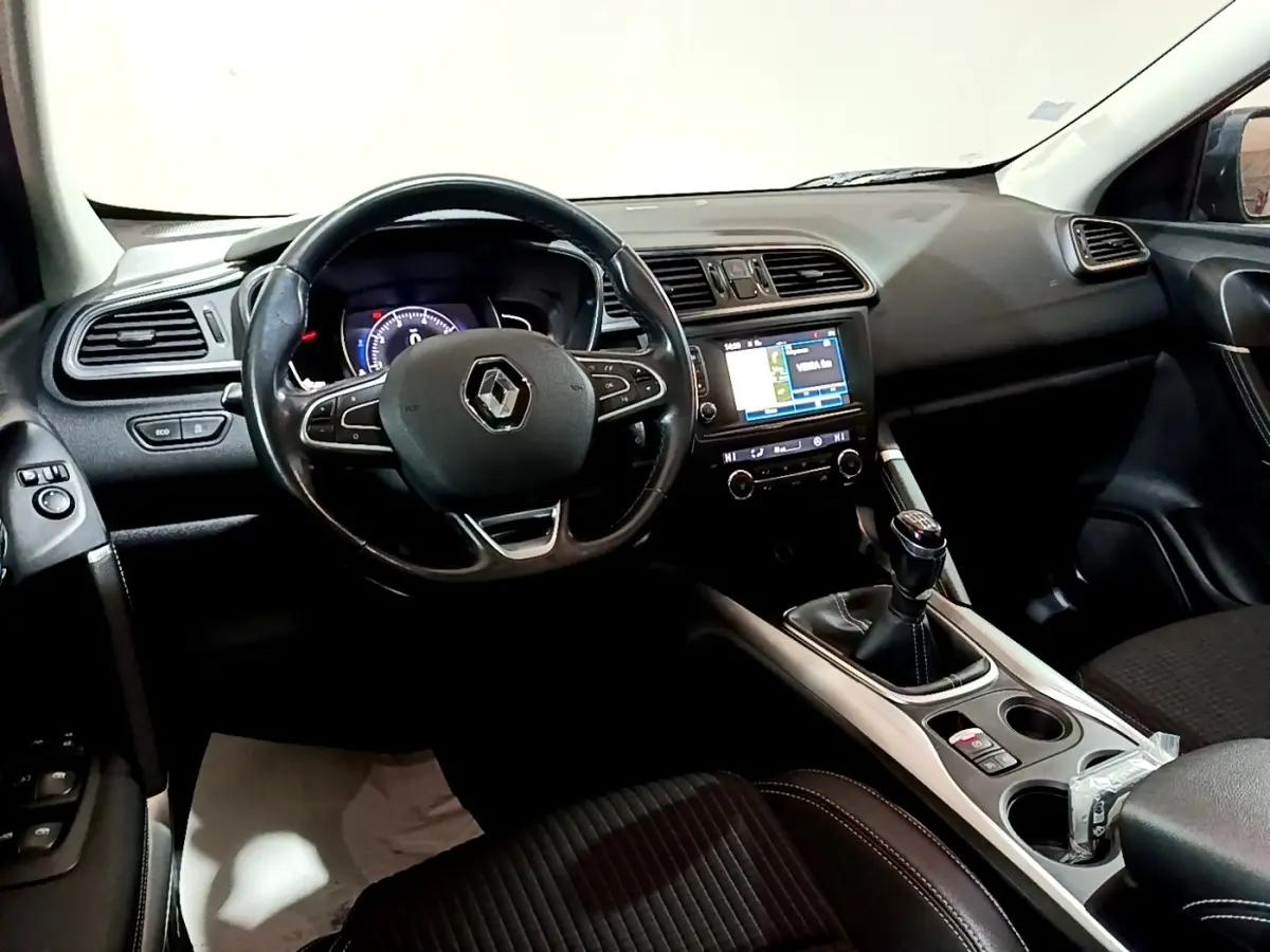 Intérieur noir du Renault Kadjar Intens 2018 vu côté conducteur, volant cuir, écran tactile et boîte manuelle visibles.