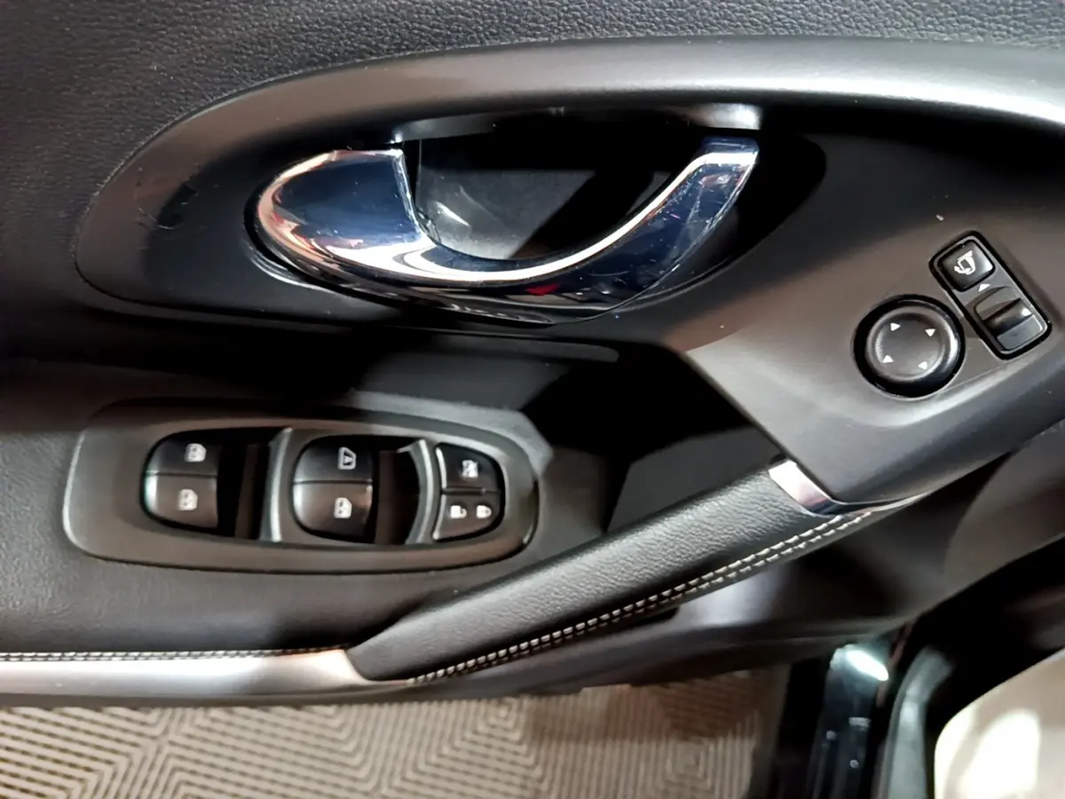 Poignée de porte intérieure chromée et commandes des vitres côté conducteur du Renault Kadjar Intens noir de 2018.